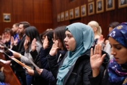 Lila Mubarak, 2nd from right, takes the Oath of Allegiance during a naturalization ceremony at the Everett McKinley Dirksen United States Courthouse in Chicago on Feb. 10, 2020.