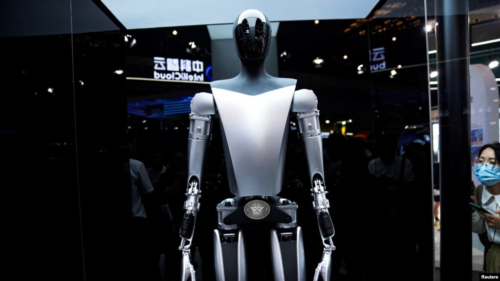资料照片：特斯拉机器人于2023年7月6日在中国上海举行的世界人工智能大会(WAIC)上展示。官媒新华社10月2日表示将出台支持政策，持续推动中国智能网联汽车产业高质量发展。中国智能汽车行业面临着地缘政治阻力以及来自特斯拉等西方同行在改进技术方面的激烈竞争。 (路透社图片)(photo:VOA)