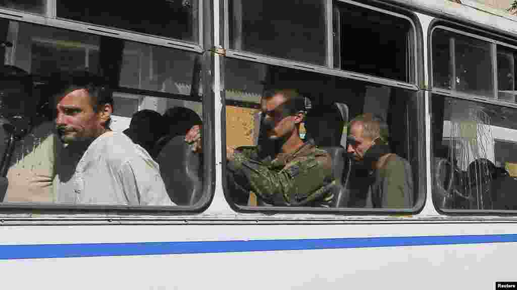 Ukrainian prisoners of war sit in a bus after being escorted for a forced-march across central Donetsk, Ukraine, Aug. 24, 2014. 