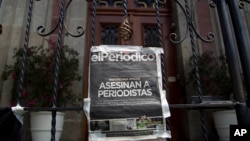 Portada del diario El Periódico de Guatemala colocada en la puerta principal de la Casa Presidencial durante una protesta para exigir la investigación de la muerte de dos periodistas.