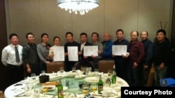 网友“超级屠夫”（吴淦）等人近日与维权律师童朝平、邬宏威、温海波、杨慧文、李方平、王宇、江天勇、陆智敏、唐吉田聚餐后，举起释放朱承志！释放陈克贵！的纸牌拍照(维权网图片)