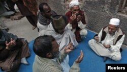 Neighbors pray outside the residence of 62-year-old heart patient Chaudhry Mohammad Gulab after he was buried in Lahore on January 27, 2012. Gulab's health started to deteriorate after he was prescribed a new medication, his younger brother said. 