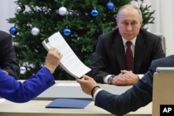 Presiden Rusia Vladimir Putin menyerahkan dokumen sebagai calon presiden Rusia pada Pilpres 2024 mendatang di Komisi Pemilihan Umum Pusat di Moskow, Rusia, Senin (18/12).