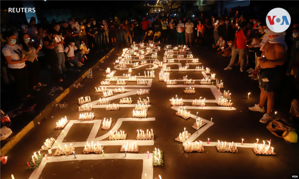 Los manifestantes encienden velas mientras participan en una protesta contra la pobreza y la violencia policial en Cali, Colombia, 5 de mayo de 2021. 