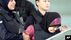 Siti Aisyah (kanan) dikawal ketat polisi saat meninggalkan pengadilan tinggi Shah Alam, Malaysia, 28 Juni 2018. (Foto: dok).