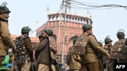 Polisi berjaga di sekitar Masjid Jama dekat gedung Benteng Merah bersejarah untuk meredam demonstrasi yang memprotes undang-undang kewarganegaraan yang diskriminatif terhadap non-Hindu, pada 20 Desember 2019. (Foto: Money Sharma/AFP)