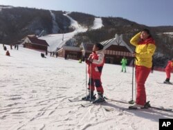 Majka i kćerka se sunčaju na skijama u skijalištu Masik Pass u Sjevernoj Koreji. (AP Photo/Eric Talmadge)