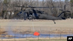 A National Guard helicopter picks up water from a small pond near Hutchinson, Kansas, March 7, 2017. Wild fires raged in parts of Kansas, Oklahoma, Texas and Colorado.