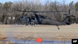 FILE - A National Guard helicopter picks up water from a small pond near Hutchinson, Kansas, March 7, 2017. Fires raged in parts of Kansas, Oklahoma, Texas and Colorado.