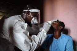 A staff member of the Ministry of Health take samples from a man during the first day of mass testing of the COVID-19 coronavirus in Djibouti on May 2, 2020.