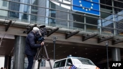 Журналист ведет съемку у здания Европарламента, где проходят обыски в рамках расследования в связи с информацией о российском вмешательстве. 29 мая 2024 г. 