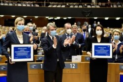 European Parliament President David Sassoli and others applaud and congratulate Belarus' opposition figures Veronika Tsepkalo (L) and Sviatlana Tsikhanouskaya during the Sakharov Prize ceremony, at the EU Parliament in Brussels, Dec. 16, 2020.