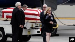 Deborah Crosby, right, walks away from her father's casket after its arrival to the airport, May 26, 2017, in San Diego. 