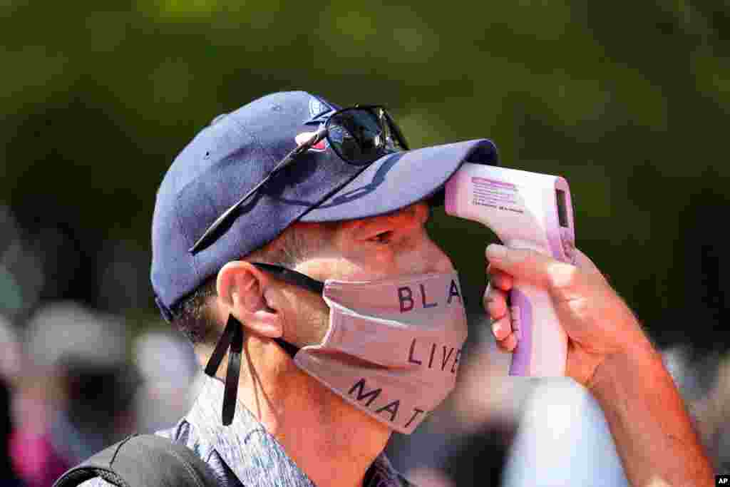 People attending the March on Washington, have their temperatures taken before entering the area, Aug. 28, 2020, at the Lincoln Memorial in Washington.