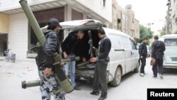 Free Syrian Army fighters carry their weapons in Sidi Meqdad area in the suburbs of Damascus, April 10, 2013, in this photo provided by Shaam News Network. 