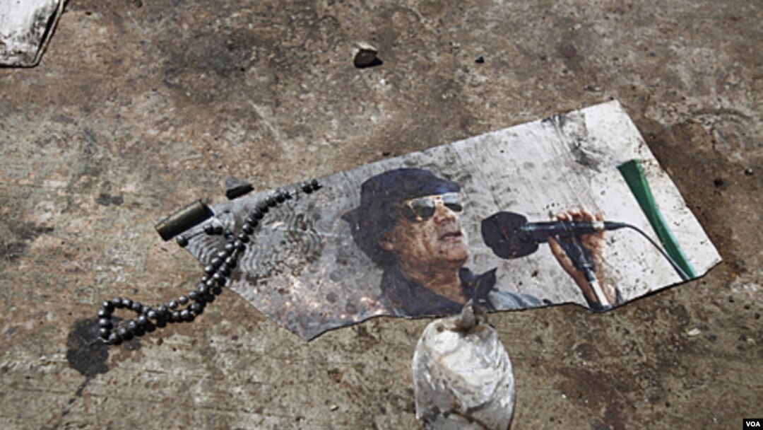 Una foto pisoteada y semidestruida de Gadhafi, se podía ver en el suelo en el complejo Bab al-Aziziya, en Trípoli.