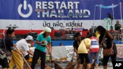 Para relawan membersihkan lokasi yang digunakan sebagai pusat protes anti-pemerintah Thailand di Bangkok (5/2). 