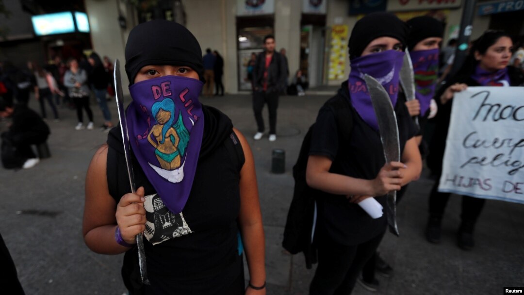 Para perempuan peserta unjuk rasa menentang kekerasan gender memegang pisau mainan di Santiago, Chile, 11 Meil 2018.