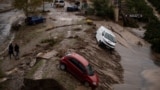 Cars taken in a mudslide are pictured in a flooded street in Alora, near Malaga, on October 30, 2024, after heavy rains hit southern Spain.