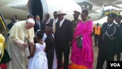 Paus Fransiskus disambut oleh anak-anak Uganda saat mendarat dari pesawat di kota Entebbe, Jumat (27/11).