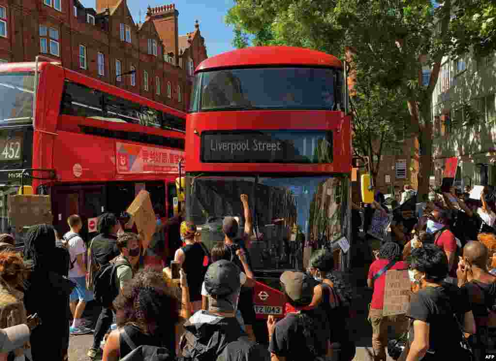 Demonstrators stop a bus as they block the street in Sloane Square in London on May 31, 2020, after marching on the US embassy to protest the death of George Floyd.