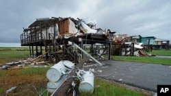 Storm clouds from approaching Tropical Storm Nicholas are seen behind homes destroyed by Hurricane Ida, in Pointe-aux-Chenes, La., Tuesday, Sept. 14, 2021. (AP Photo/Gerald Herbert)