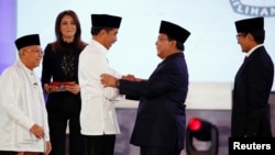 Capres 01 Joko Widodo (kiri) berjabat tangan dengan Capres 02 Prabowo Subianto sementara Cawapres 01 Ma'ruf Amin dan Cawapres 02 Sandiaga Uno menyaksikan usai debat pertama di Jakarta, Kamis malam (17/1). 