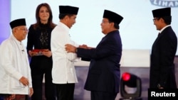 Capres 01 Joko Widodo (kiri) berjabat tangan dengan Capres 02 Prabowo Subianto sementara Cawapres 01 Ma'ruf Amin dan Cawapres 02 Sandiaga Uno menyaksikan usai debat pertama di Jakarta, Kamis malam (17/1). 