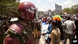 A riot policeman stands guard as opposition party supporters shout slogans during a march in Nairobi, Kenya, Oct. 9, 2017. 