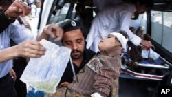 A Pakistani man lifts a girl injured in a suicide attack from an ambulance to be treated at a hospital in Peshawar, 05 Mar 2010