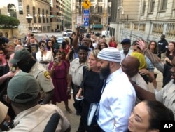 FILE - Adnan Syed, center-right, leaves the Cummings Courthouse, in Baltimore, Maryland, Sept. 19, 2022.