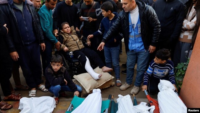 İsrail saldırılarında yaralanan Filistinli bir çocuk, Han Yunus'ta bulunan Nasır Hastanesi'nde, öldürülen aile üyelerinin cenazesine katıldı. (10 Aralık 2023)