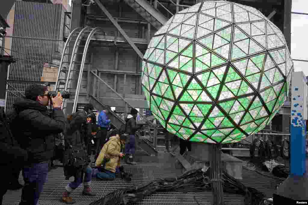 Para fotografer memotret bola yang akan jatuh pada tengah malam, sebelum perayaan malam tahun baru di Times Square, New York (30/12). (Reuters/Carlo Allegri)