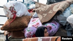 正值黎巴嫩和以色列为期10天的停火期间，一名流离失所的黎巴嫩妇女搭乘一辆满载家当的卡车，踏上返回南部家园的归途。(2026年4月20日)