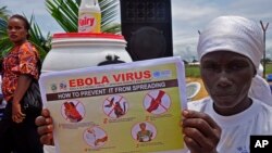 Seorang perempuan Liberia memegang pamflet mengenai panduan bagaimana mencegah Ebola dari penyebarannya di kota Monrovia, Liberia. 