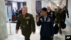FILE - U.S. Marine Corps Gen. Kenneth McKenzie, left, head of U.S. Central Command, walks to a House Armed Services Committee hearing on Capitol Hill, March 10, 2020, in Washington. McKenzie spoke with senators March 12.