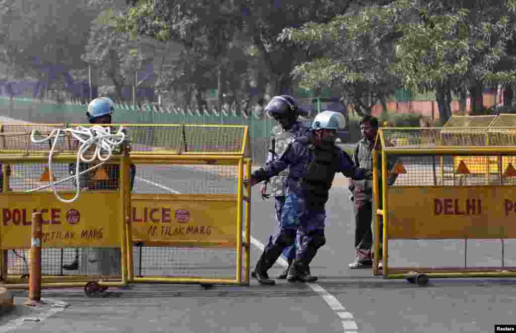 A member of the Rapid Action Force (RAF) pulls a barricade to close a road leading to the India Gate in New Delhi December 29, 2012. An Indian woman whose gang rape in New Delhi triggered violent protests died of her injuries on Saturday in a Singapore ho