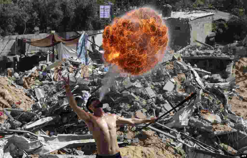 Palestinian members of Gaza&#39;s Bar Woolf sports team perform with fire on the ruins of a building destroyed in recent Israeli airstrikes, in Beit Lahia.