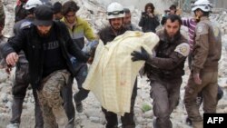 Des membres des Casques blancs syriens retirent une victime des décombres d'un bâtiment détruit suite à une attaque aérienne à Idleb, Syrie, le 15 mars 2017.