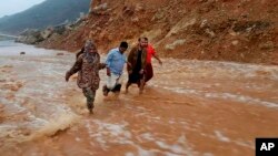 Men walk on a road flooded after heavy rain and strong winds caused damage in Hadibu as Cyclone Mekunu pounded the Yemeni island of Socotra, May 24, 2018. At least 17 people were reported missing and presumed dead. The powerful storm remained on path to strike Oman this weekend.