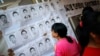 A woman looks at pictures of the 43 missing students from the Ayotzinapa teachers' training college during a demonstration to demand justice for them, outside of the National Human Rights Commission, (CNDH) in Mexico City, November 6, 2014. The students w