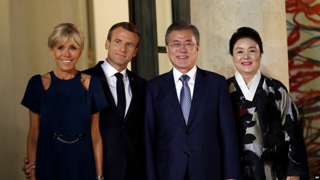 Presiden Korea Selatan Moon Jae-in (tengah kanan), istrinya Kim Jung-sook (kanan), Presiden Perancis Emmanuel Macron (tengah kiri) dan istrinya, Brigitte, berpose sebelum jamuan makan malam kenegaraan di Istana Elysee, di Paris, Senin, 15 Oktober 2018.