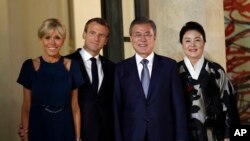 Presiden Korea Selatan Moon Jae-in (tengah kanan), istrinya Kim Jung-sook (kanan), Presiden Perancis Emmanuel Macron (tengah kiri) dan istrinya, Brigitte, berpose sebelum jamuan makan malam kenegaraan di Istana Elysee, di Paris, Senin, 15 Oktober 2018.