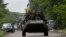 Ukrainian soldiers ride atop an Armored Personnel Carrier (APC) near the site where pro-Russia rebels killed Ukrainian servicemen in the outskirts of the eastern Ukrainian town of Volnovakha, south of Donetsk May 22, 2014.