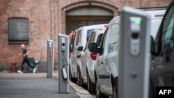 FILE - Electric cars are being charged on a street in the Norwegian capital Oslo, April 30, 2019.