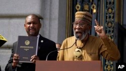 FILE —Rev. Amos Brown speaks during a rally in support of reparations for African Americans as Supervisor Shamann Walton, left, listens outside City Hall in San Francisco, on September 19, 2023. 