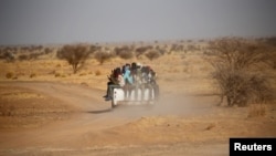 FILE - Migrants crossing the Sahara desert into Libya ride on the back of a pickup truck outside Agadez, Niger, May 9, 2016. The International Organization for Migration said on March 22, 2024, that the bodies of at least 65 migrants were discovered in a mass grave in Libya.