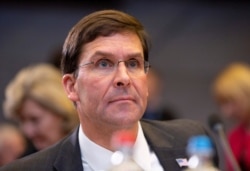 FILE - U.S. Secretary for Defense Mark Esper waits for the start of a meeting of NATO defense ministers at NATO headquarters in Brussels, Belgium, Oct. 24, 2019.