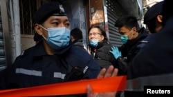 FILE - Daniel Wong Kwok-tung, a lawyer who tried to help the 12 people detained in mainland China, is escorted by police as he returns to his office in Hong Kong, China, Jan. 14, 2021.