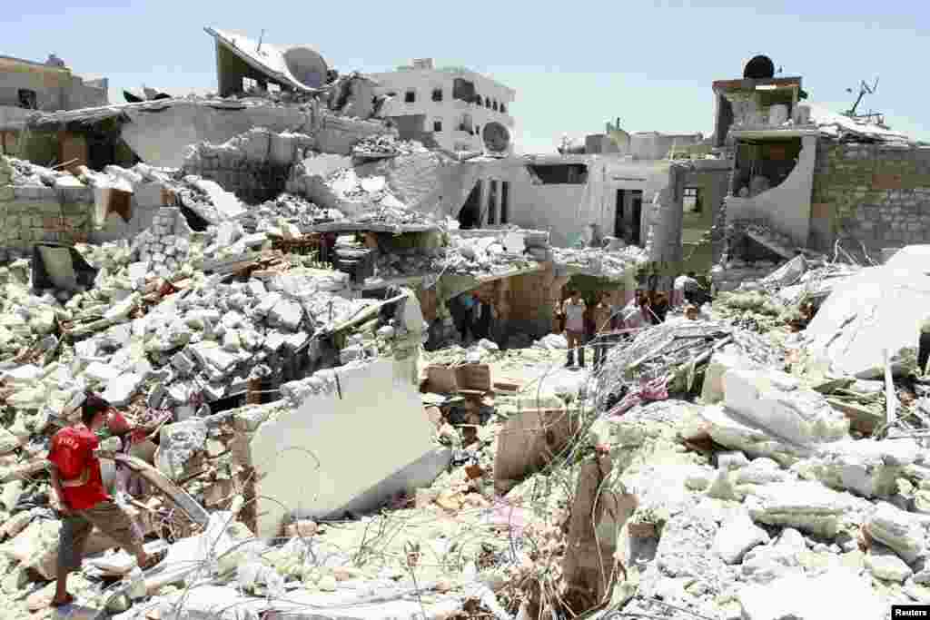 Residents rummage through the damage and debris left of their homes for their belongings after what activists said was an air attack from forces loyal to Syria's President Bashar Al-Assad in Bab Neirab, Aleppo July 27, 2013. REUTERS/Hamid Khatib (SYRIA - 